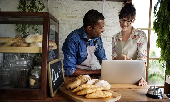 man and woman looking at the laptop